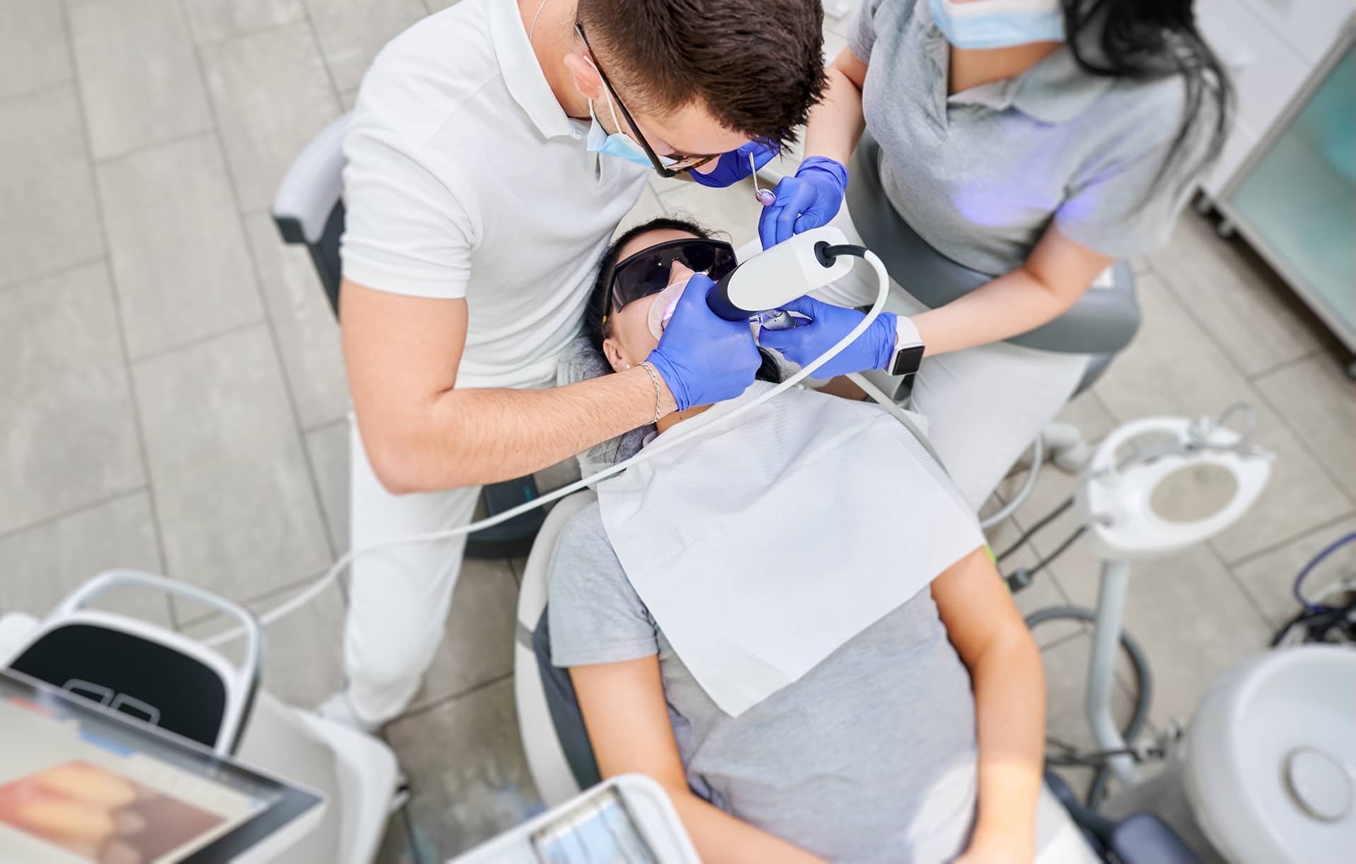 doctor-and-assistant-examining-patient-teeth-with-2025-01-16-23-08-40-utc 1